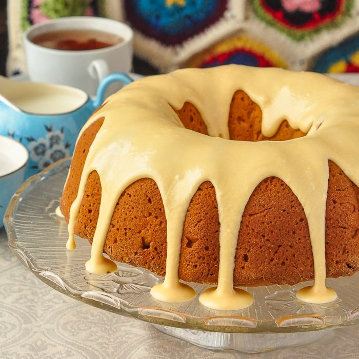 Photo of uncut applesauce cake on a clear glass pedestal