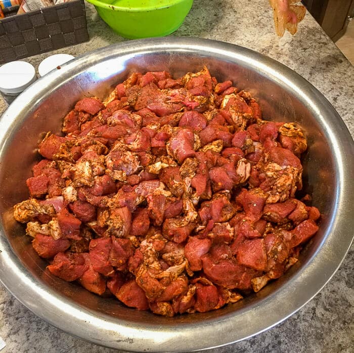 Grinding Pork for Cuban Sandwich Burgers. Shows seasonings tossed with cubes of pork