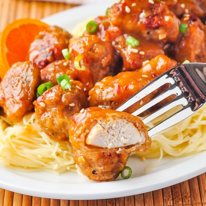 Orange Chicken photo of a piece of cooked chicken on a fork