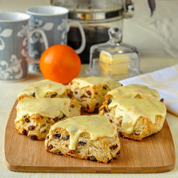 Orange Raisin Scones wide shot of scones on wooden board with coffee in background