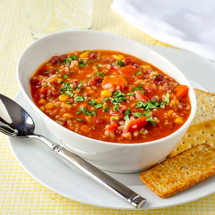 Dirty Rice and Beans Soup photo of a single serving in white bowl with crackers on the side