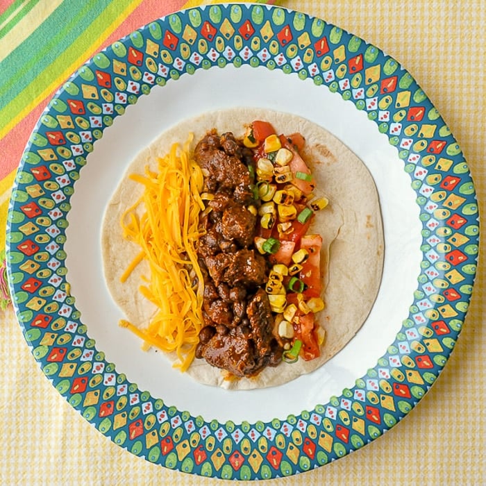 Beef Tacos From the Slow Cooke single taco on multicoloured plate