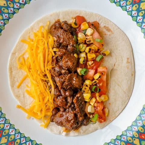 Beef Tacos From the Slow Cooker close up of single serving with grilled corn salsa