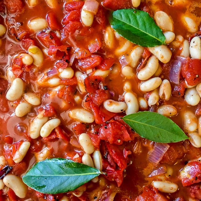 Chicken Braised in Fire Roasted Tomato Sauce photo of beans and tomatoes going into the pot