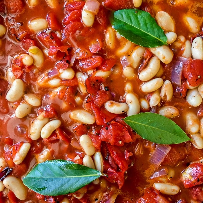 Chicken Braised in Fire Roasted Tomato Sauce photo of beans and tomatoes going into the pot 