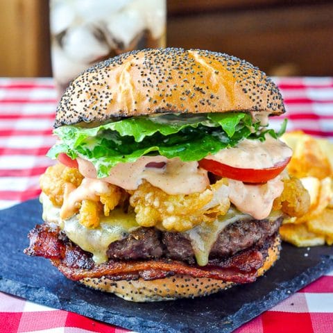 Completed Barbecue Spice Burger swith potato chips on a slate serving plate