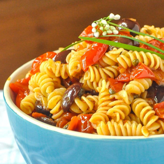 Puttanesca Pasta Salad close up photo of salad in a blue serving bowl