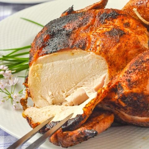 Beer Butt Chicken photo of chicken being carved with a hive flower garnish