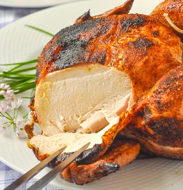 Beer Butt Chicken photo of chicken being carved with a hive flower garnish