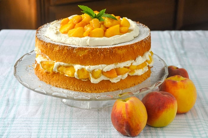 Bourbon Peach Shortcake photo of uncut cake with fresh peaches on the side