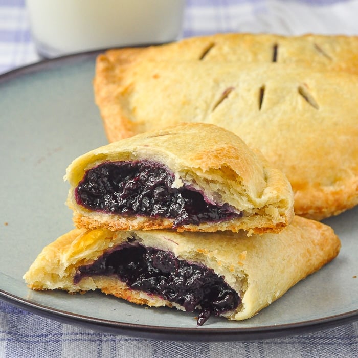 Blueberry Turnovers on a blue plate with milk in the background