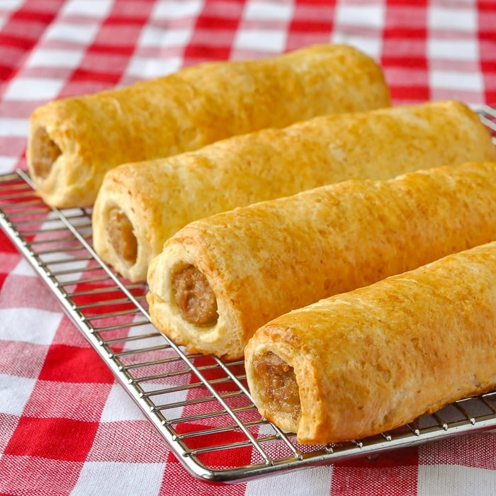 Buttermilk Biscuit Sausage Rolls cooling on a wire rack on a red checkered tablecloth