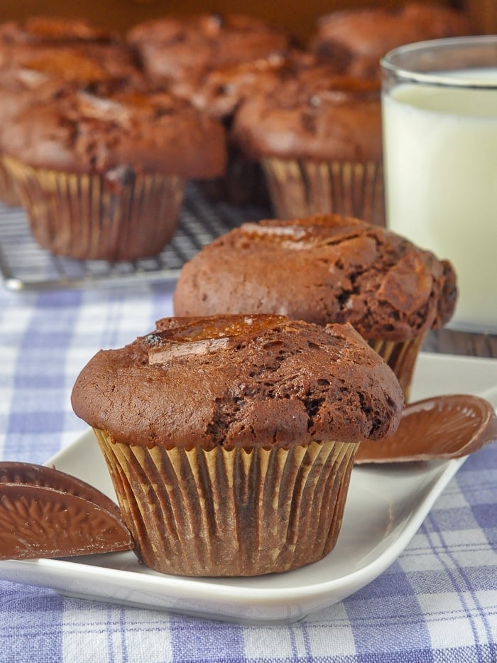Terry's Chocolate Orange Muffins on a white serving plate with glass of milk in background