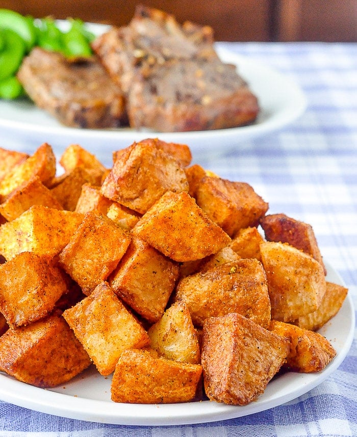 Barbecue Spice Mix Seasoning on Hash Browns with grilled steak in the background