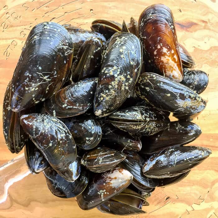 Fresh mussels in a clear glass bowl.