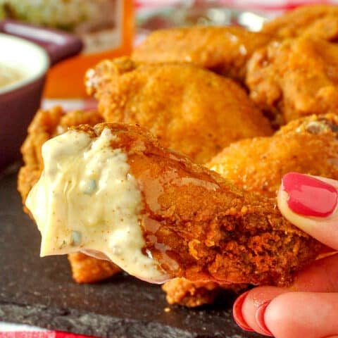 Southern Fried Wings Close up photo of one wing dipped in the aioli