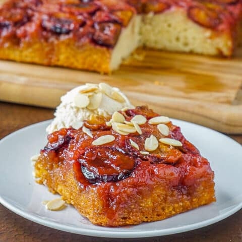 Almond Plum cake photo of a serving on a white plate with ice creaam