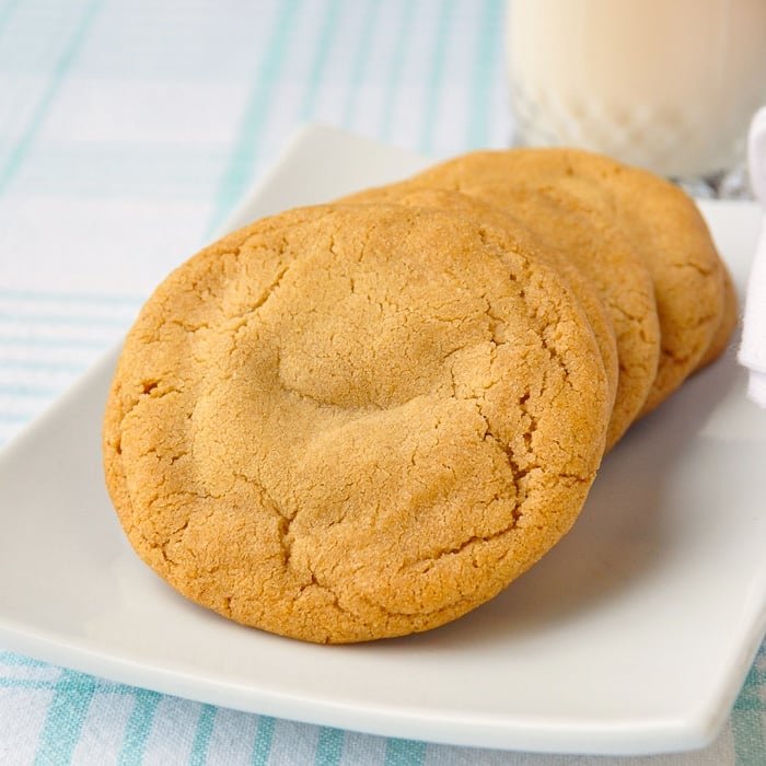 Caramel Stuffed Brown Butter Cookies on a white plate with glass of milk in background