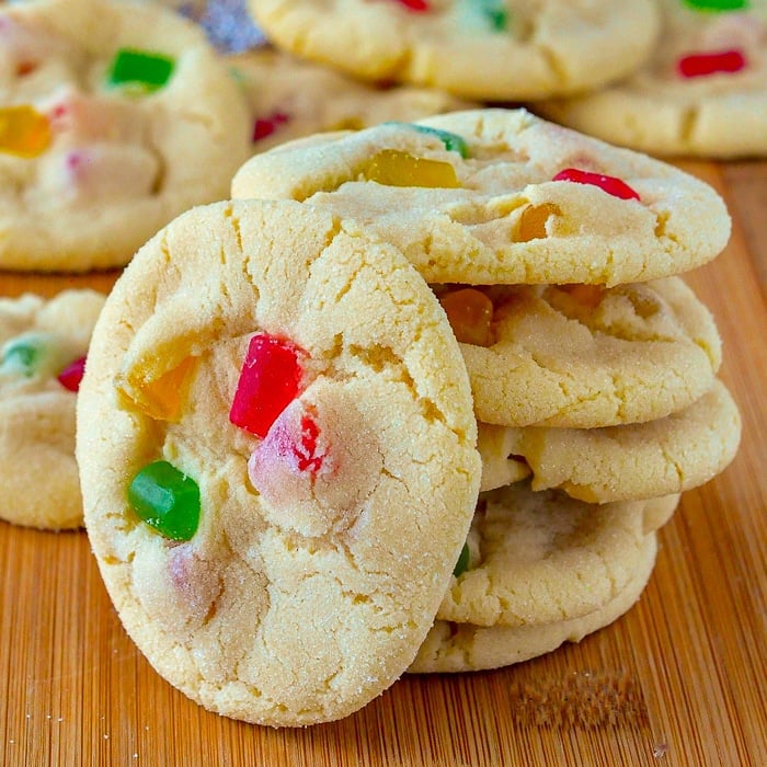 Close up photo of Gumdrop Sugar Cookies stacked on a wooden cutting board