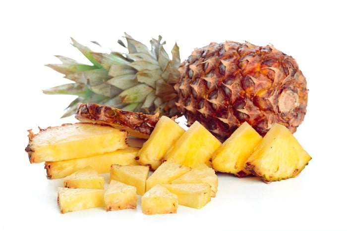 Fresh Golden Pineapple cut in pieces on white background.