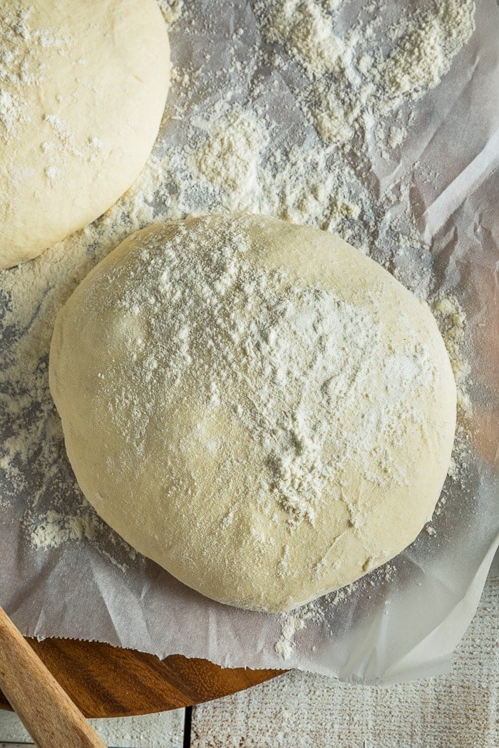 Balls of pizza dough on a wooden cutting board