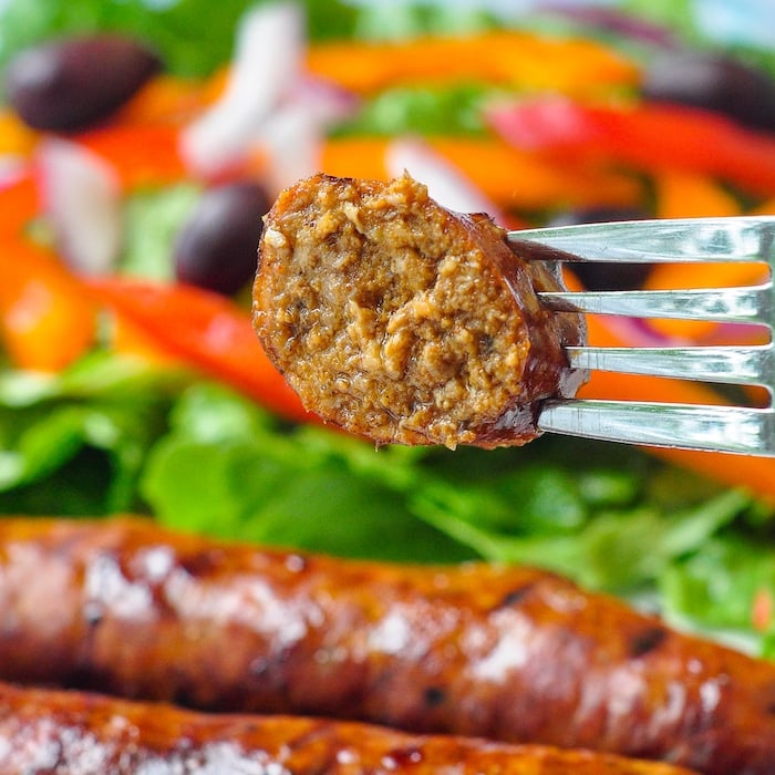 Homemade Chorizo Sausage shown close up with cut piece of sausage on a fork