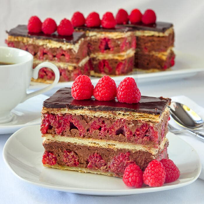Raspberry Chocolate Mille Feuilles. close up pohoto of one serving on a white plate.