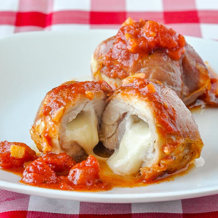 Stuffed Chicken Thighs with Prosciutto Mozzarella and Quick Tomato Sauce showing cheese melted at centre.