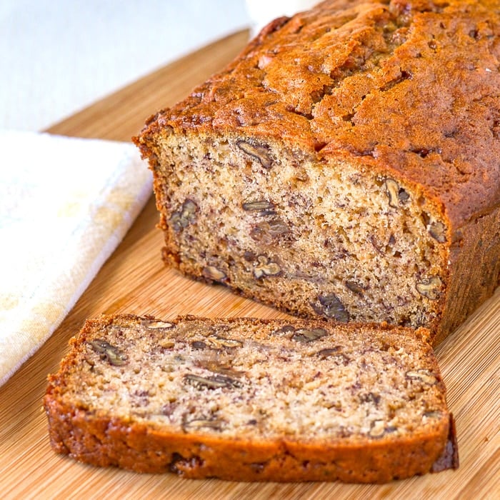 Toffee Pecan Banana Bread close up photo of cut loaf on a cutting board