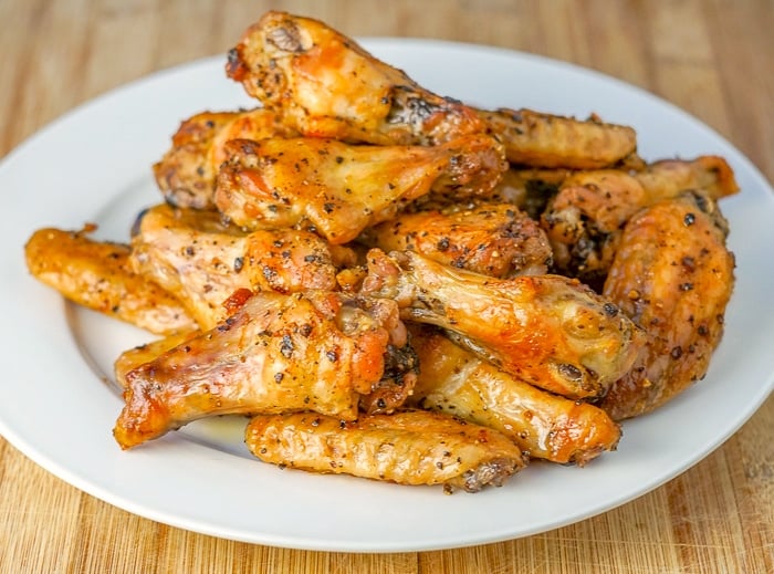 Salt and Pepper Wings wide shot of wings piled on white serving plate.