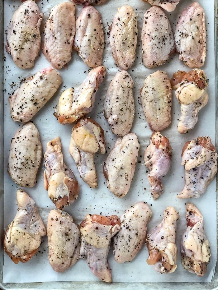 Salt and Pepper Wings well seasoned on a parchment paper lined cookie sheet ready for the oven
