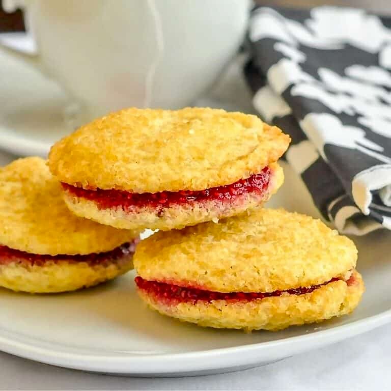 Raspberry Vanilla Butter Cookies close up photo of 3 cookies on a white plate.