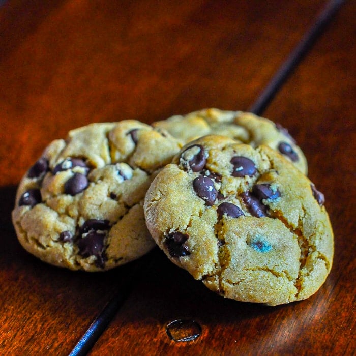The Best Peanut Butter Chocolate Chip Cookies photo of 3 cookies on a wooden table top