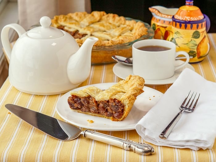 Rum Raisin Pie wide shot of the pie with a tea service on yellow table cloth