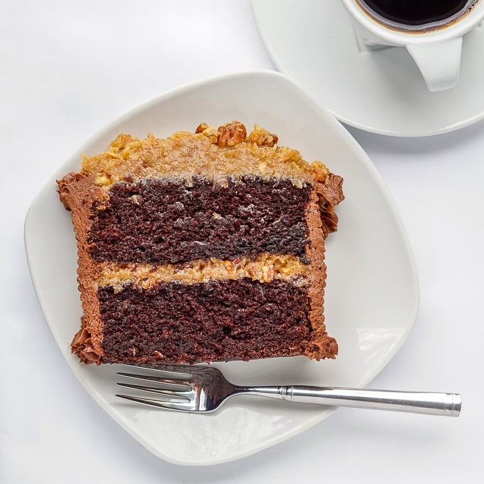 German Chocolate Cake photo of single serving on a white plate.