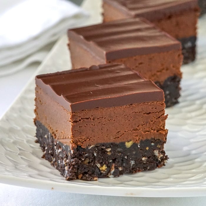 Chocolate Nanaimo Bars close up photo of a single cookie bar on a white platter