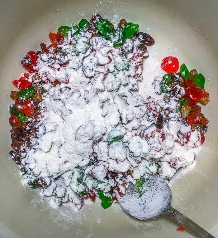 Photo showing dusting the fruit helps prevent it sinking to the bottom of the pan