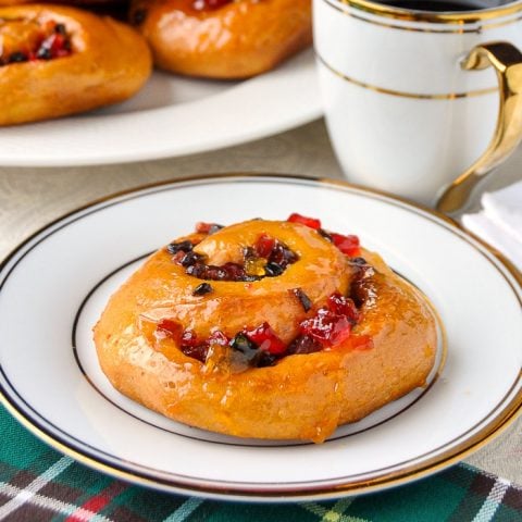 Christmas Chelsea Buns close up phopto of one bun with a gold and white coffee service