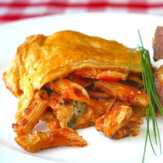 Close up photo of Chicken Penne Timpano on a white plate formatted for featured image
