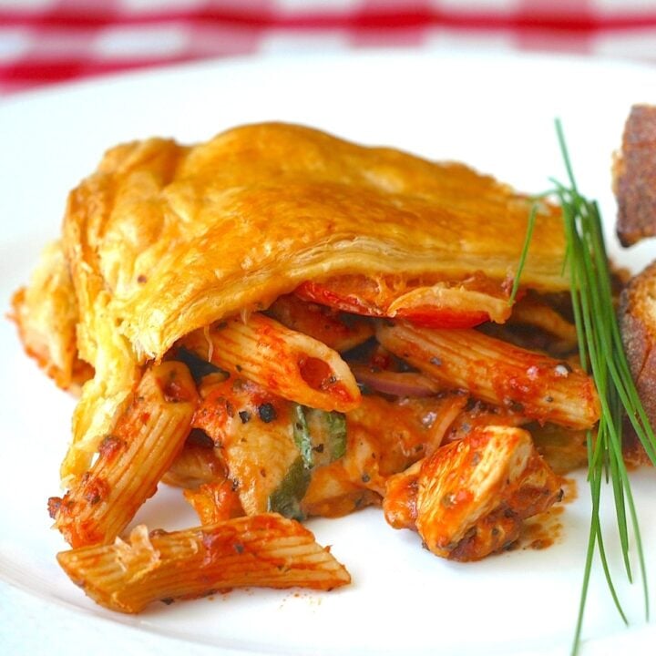 Close up photo of Chicken Penne Timpano on a white plate formatted for featured image