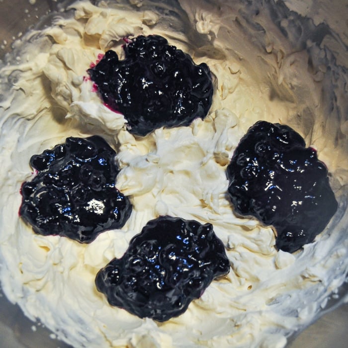 Adding the blueberry compote to the whipped cream