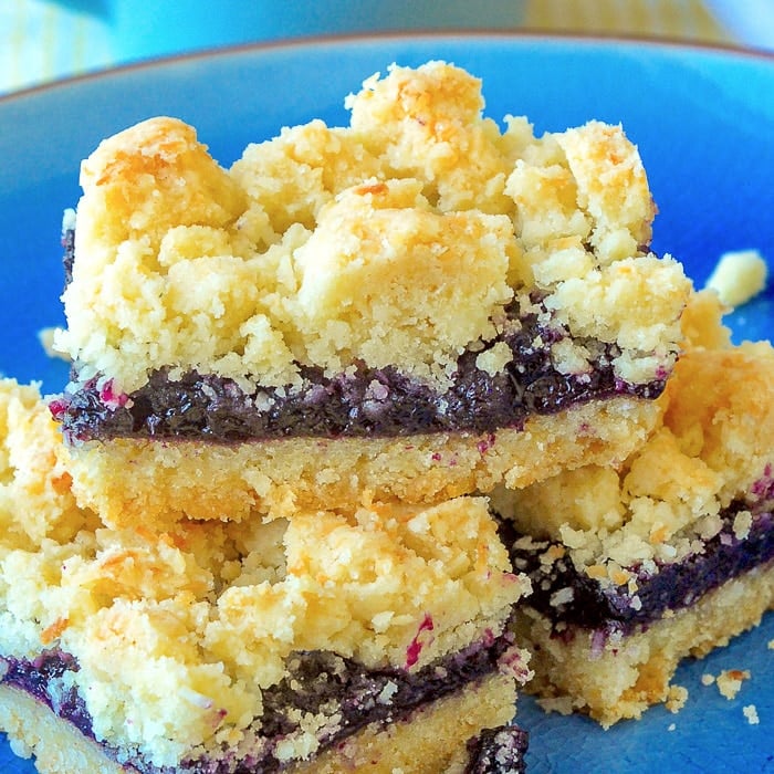 Blueberry Coconut Crumble Bars close up photo of cookie bars on a blue plate