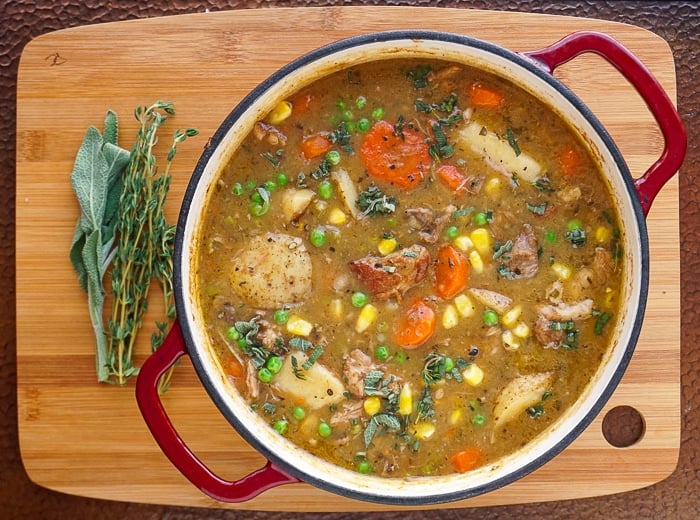 Finished Pot of pork stew with herbs on the side