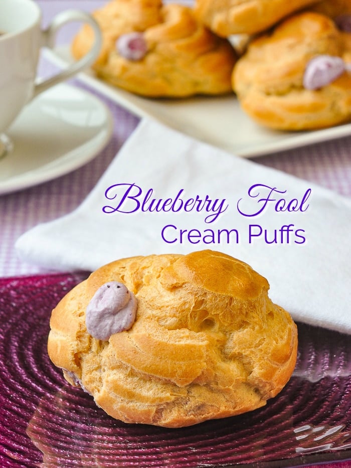 One Blueberry Fool Cream Puffs photop pf pne cream puff on a purple glass plate with text added for Pinterest