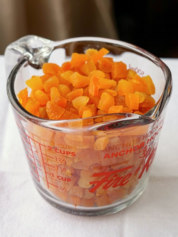 Chopped dried apricots in a clear measuring cup