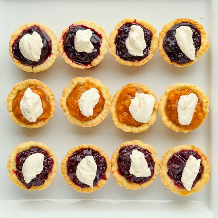 Close up overhead photo of Jam tarts with topped with cream