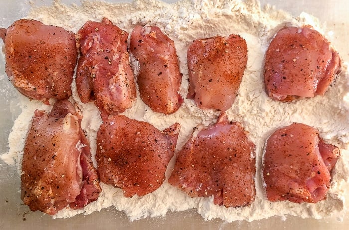 Dredge the seasoned chicken pieces in plain flour