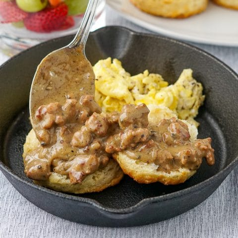 Southern Sausage Gravy biscuits and scrambled eggs in a cast iron pan