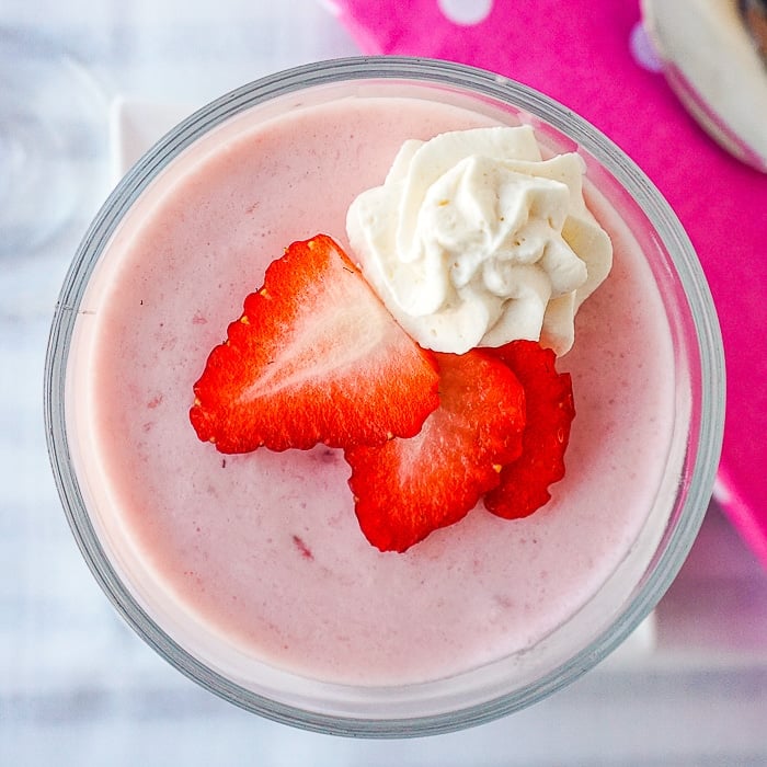 Strawberry Marshmallow Mouuse. Overhead shot of a single serving garnished with strawberry slices and whipped cream