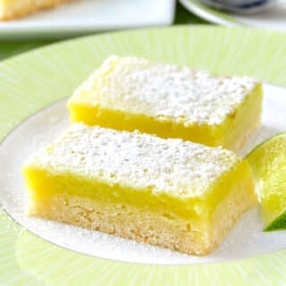 Super Easy Lime Bars with lime wedge on a green and white plate